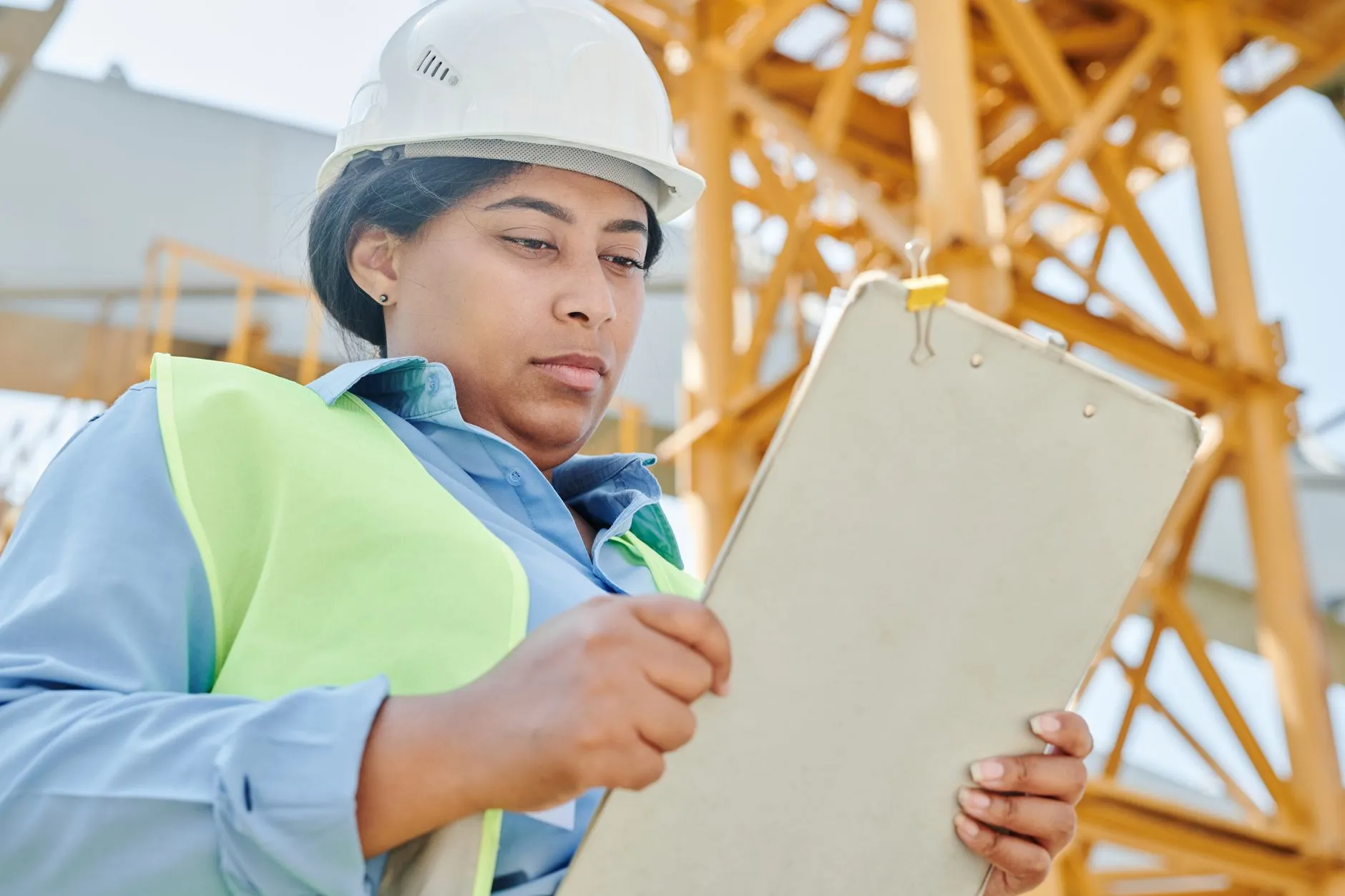A worker in a hard hat completing a safety compliance checklist on site — Avaib