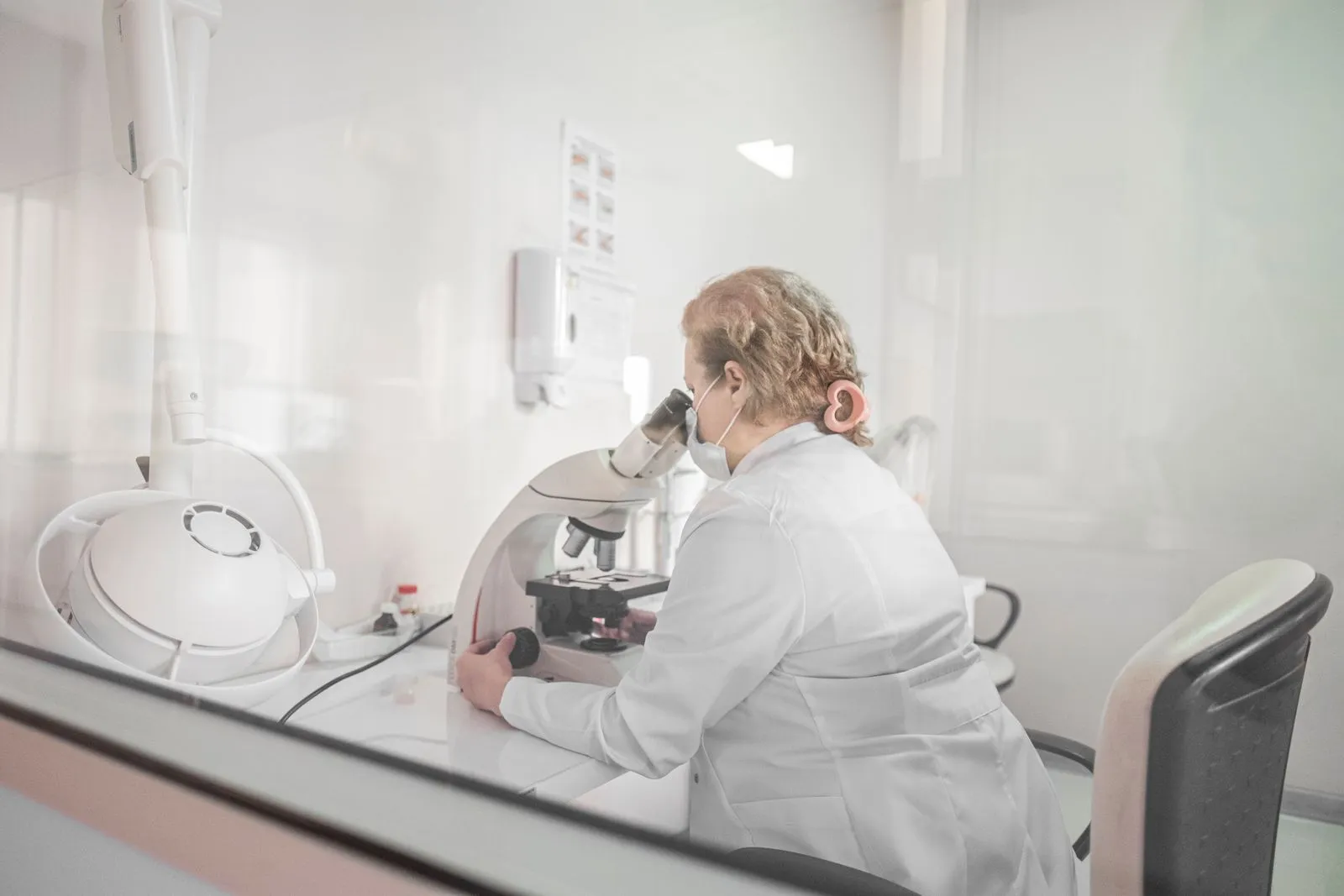 A laboratory researcher working at a microscope — Avaib