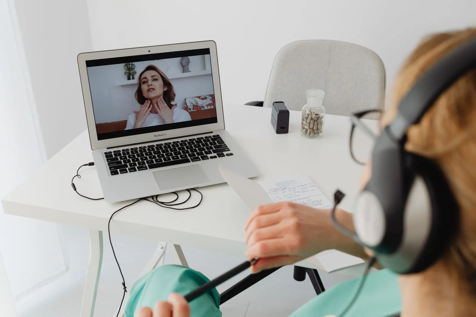 A clinician on a telehealth video call at a laptop — Avaib