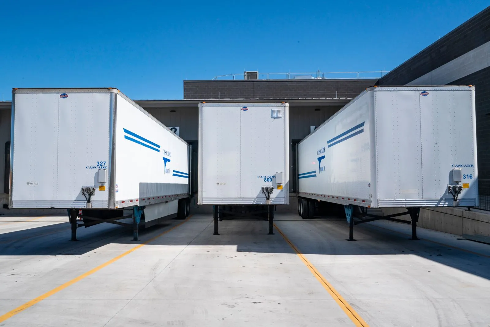 A fleet of delivery trucks at a loading dock — Avaib