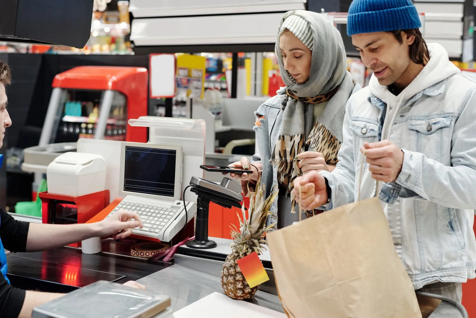 A customer paying at a store checkout counter — Avaib