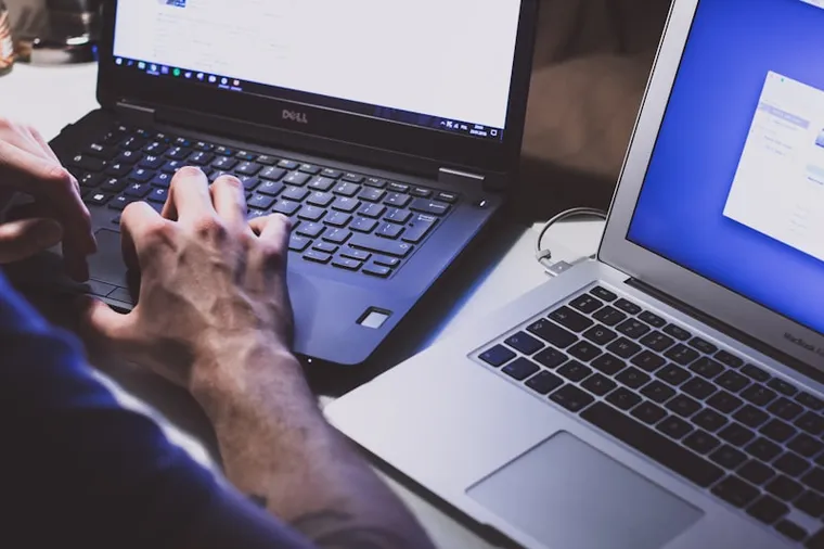 A software tester checking code on a laptop