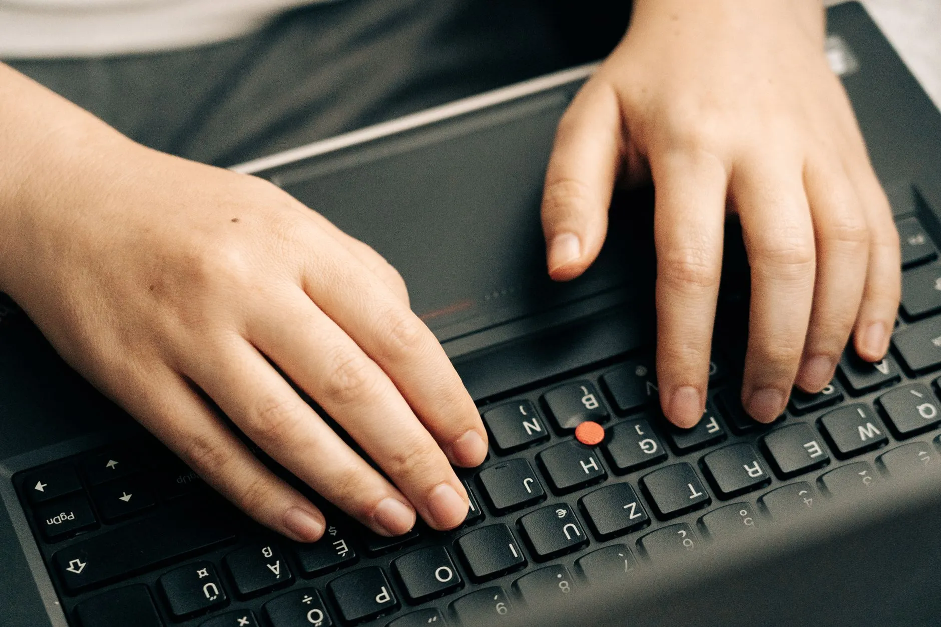 A person typing data into a computer transferring information between systems — Avaib